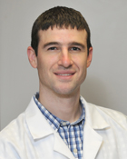 greg stahly, young pharmacist in white coat with short brown hair
