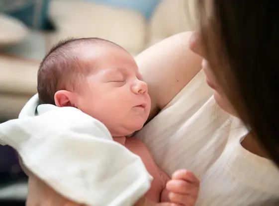 Una madre con un bebé envuelto en una manta